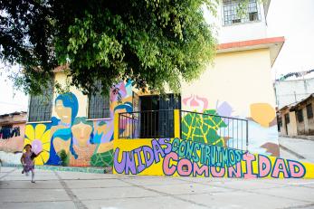 A mural at a school reading "Unidas construimos comunidad"