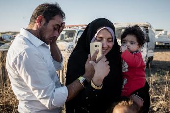 Family talking on phone in Hasansham camp