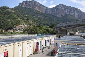 Scene of temporary shelters at port at base of mountain