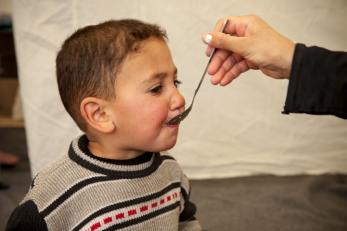A young boy being fed from a spoon