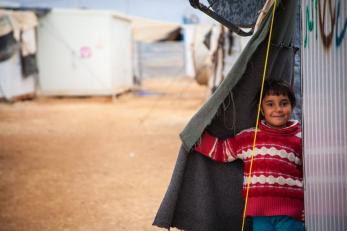 smiling boy looking out from shelter