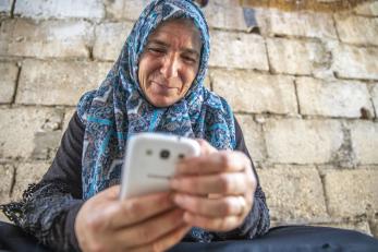 A Syrian refugee uses her mobile phone to access digital banking services in Jordan.