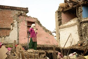 A woman in Nepal standing among rubble after the earthquake