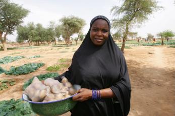 woman holding produce in field