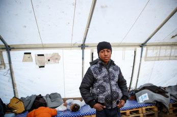 A boy in a black and white jacket in a shelter