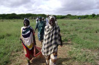 women walking through field