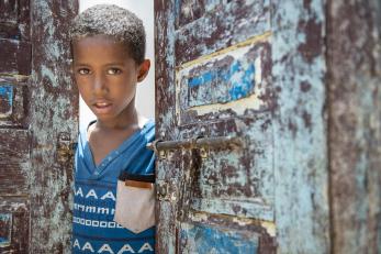 A boy looking through a doorway