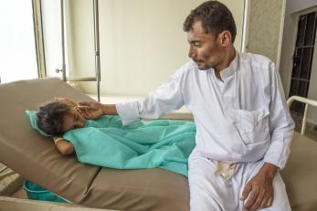 Abdullah sits with his 7-year-old daughter Nehan as she receives treatment for cholera at a Mercy Corps-supported health clinic in Yemen. More than 1 million cholera cases have been reported since April 2017. Photo: Ezra Millstein/Mercy Corps