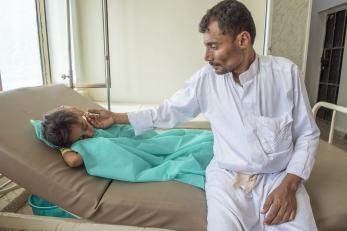 Father consoling sick child in hospital 