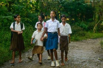 Lourdes walks to school in the company of younger classmates in Timor Leste