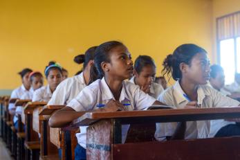 Students at desks in a yellow classroom