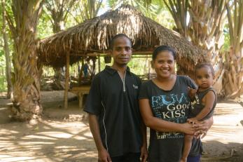 A man and woman holding a baby in Timor Leste