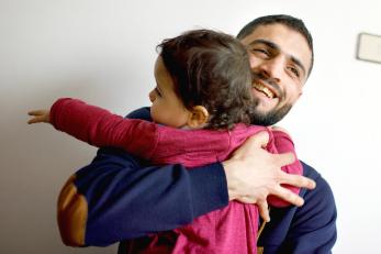 Father hugging child.