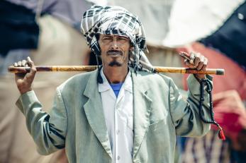 A portrait of a pastoral beneficiary holding a stick in Kebribeyah, Ethiopia.