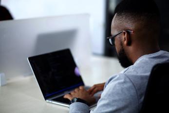 A person sits at a laptop computer.