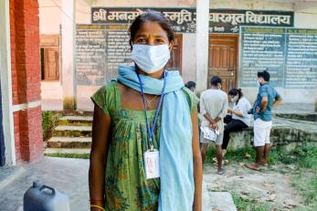 A person faces the camera while wearing a face mask. 