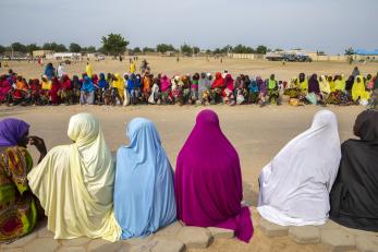 Women and children wait in line for a monthly food distribution in Fulatari camp.