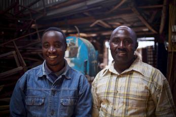 Two individuals stand next to each other and smile for the camera.