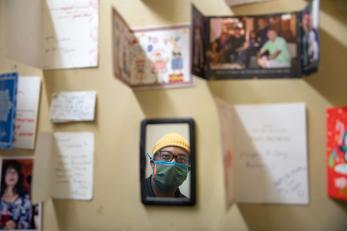 On a wall inside a small storage room a person looks at the various greeting cards he and his father have received from their clients over the years.