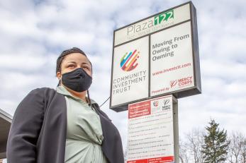 A person standing outside a neighborhood commercial-retail space. 