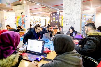 Young people working in an office place together.