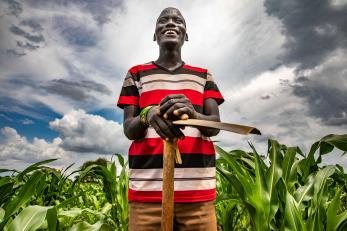 A farmer poses in their maize field.