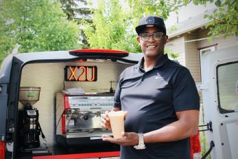 Eddy Holford holding beverages he made with his mobile café business vehicle.