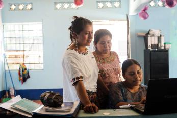 Three people using a computer.