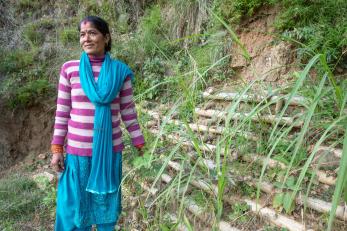 A person standing near a bamboo embankment.