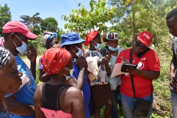 In Grand'Anse, Haiti, a Mercy Corps team member helps farmers set up mobile accounts for emergency cash aid transfers.
