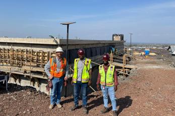 In DRC, three members of the Mercy Corps’ infrastructure team pose together, including engineer Simeon Kakule (center).