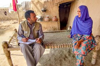 A Mercy Corps team member listening to someone speaking.