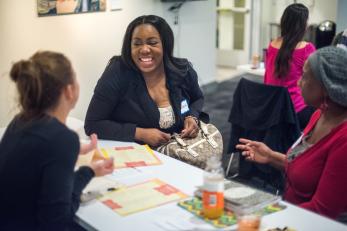 three women sitting at a table laughing