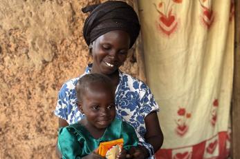 a seated mother holding her small child