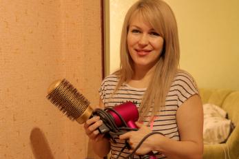 woman standing with brush and hairdryer