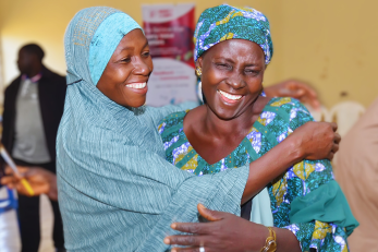 Two people smiling as they share an embrace.