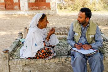 A mercy Corps team member listening to a community member speaking.