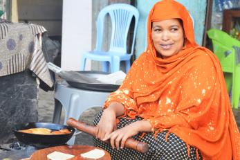 An entrepreneur sitting down and rolling dough.