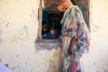 A person handing another cash through a window.