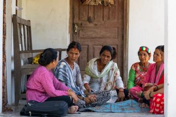 Nepalese community members sit in discussion.