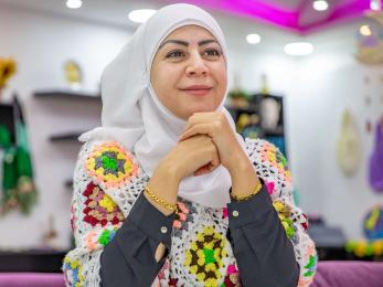 A business owner sits among her handicrafts in her shop in Jordan.