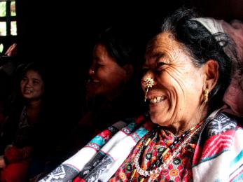 A person smiling in a room of people.
