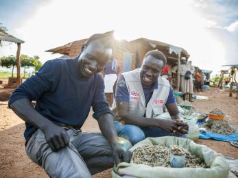 A Project Officer for Mercy Corps, talks to Festo James, a South Sudanese refugee and beneficiary of the DREAMS Program.