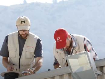 Two Mercy Corps employees installing technology.