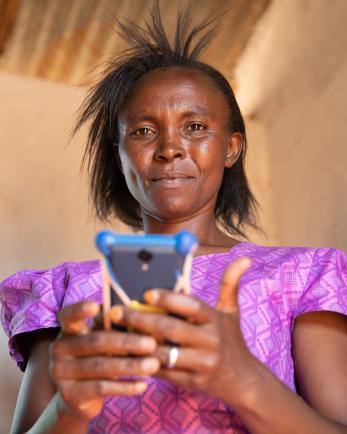 woman in Kenya holding a phone