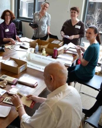 Mercy Corps volunteers of all ages at a table stuffing envelopes