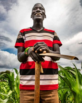 A farmer poses in their maize field.