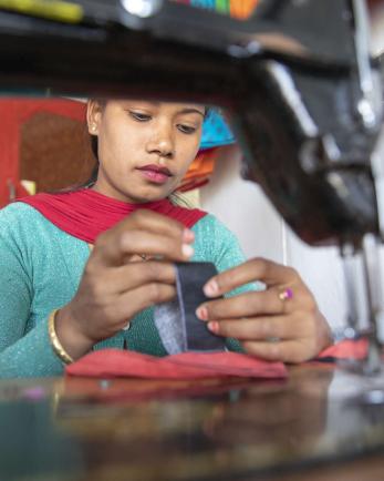 Nepalese woman at sewing machine.