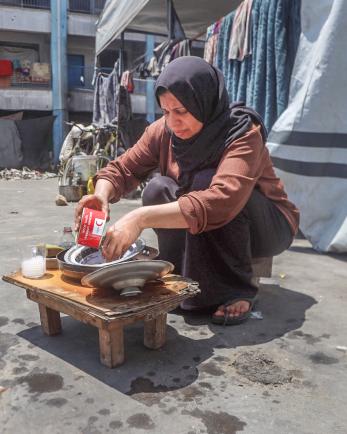 A woman in Gaza cleans her family's food bowls