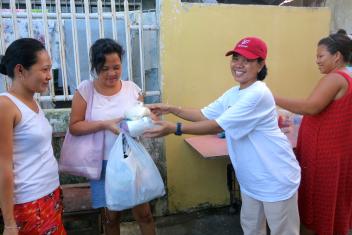 Dewi Hanifah distributed food and hygiene supplies to women who have been waiting days for help. Photo: Mercy Corps